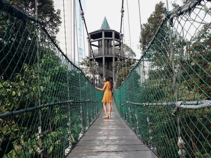 Girl walking on canopy bridge at the KL Forest Eco Park 