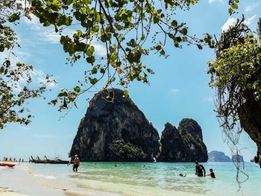 people swimming at phra nang beach with limestone rocks in the backdrop