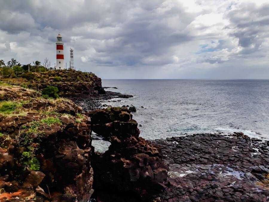 a red and white lighthouse sitting on top of a cliff at Albion mauritius