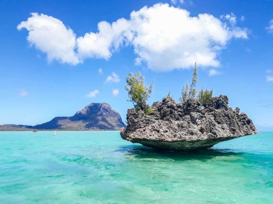 view of crystal rock surrounded by turquoise waters with le morne brabant in the backdrop