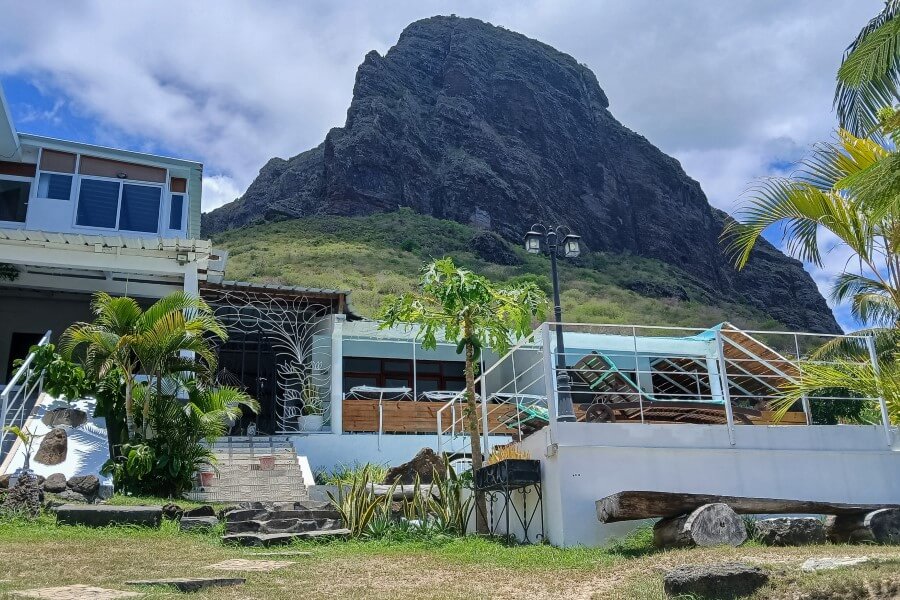 a white building at the foot of a mountain in le morne mauritius