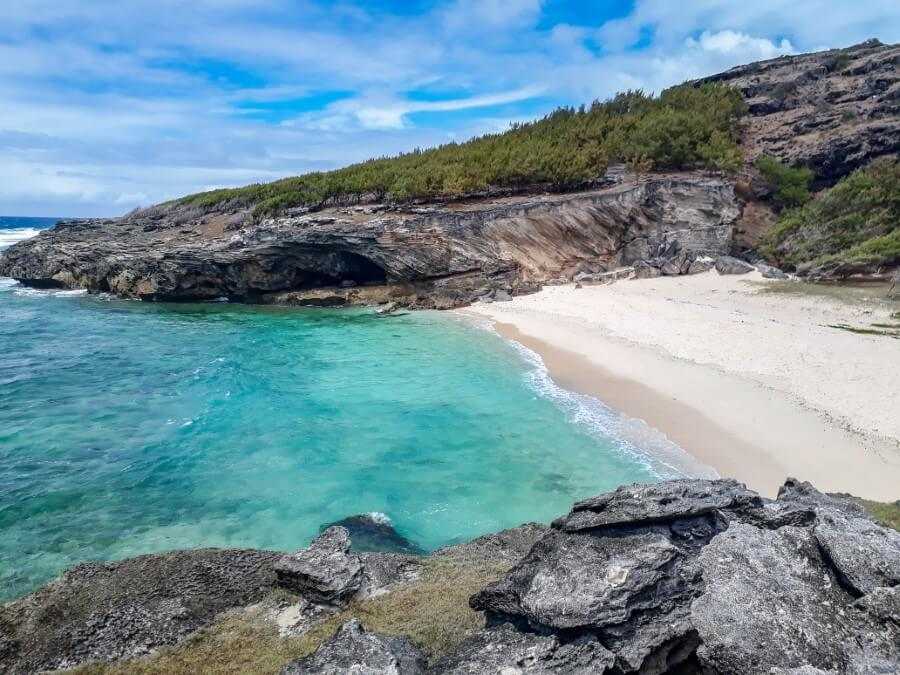 a white sand beach flanked by jagged cliffs at Rodrigues Island