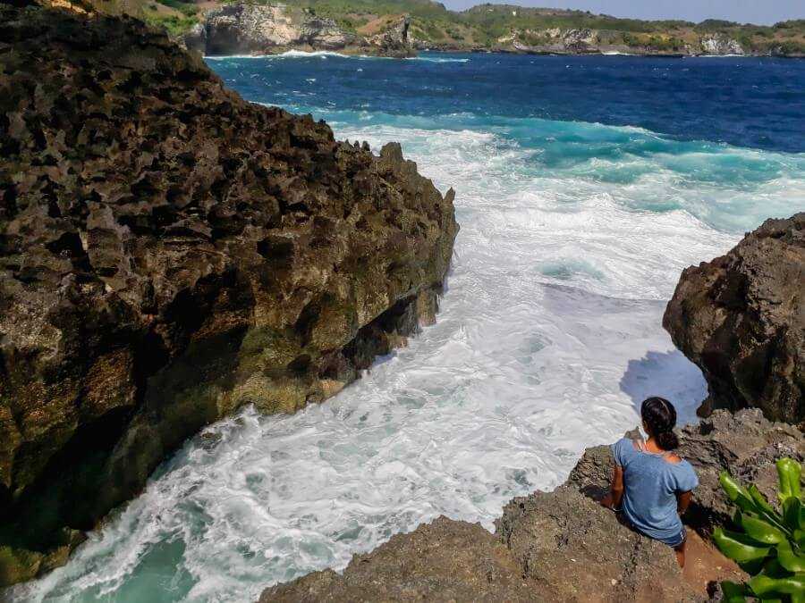 Girl admiring the waves crashing into Angel's Billabong infinity pool