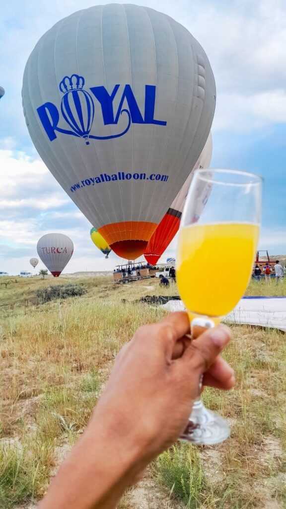 a glass of champagne with royal balloon in the backdrop