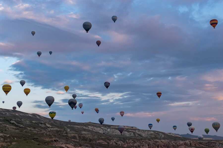 hundreds of colorful hot air balloons against a pink sky of turkey