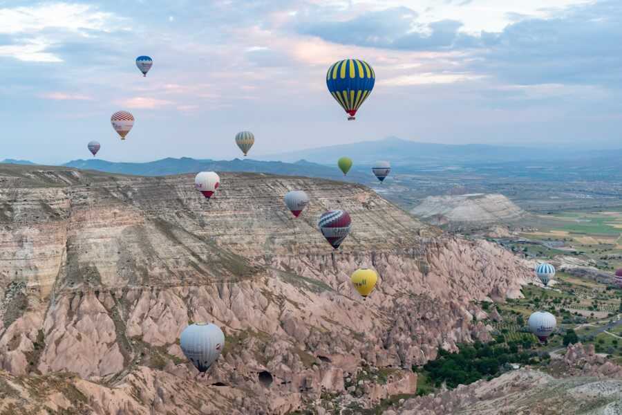 hot air balloons against a pink mountain