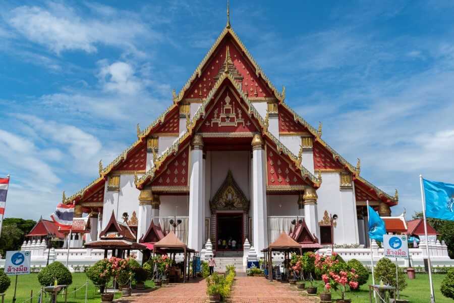 a white, red and gold temple housing a buddha statue at Wihan Phra Mongkhon Bophit ayutthaya
