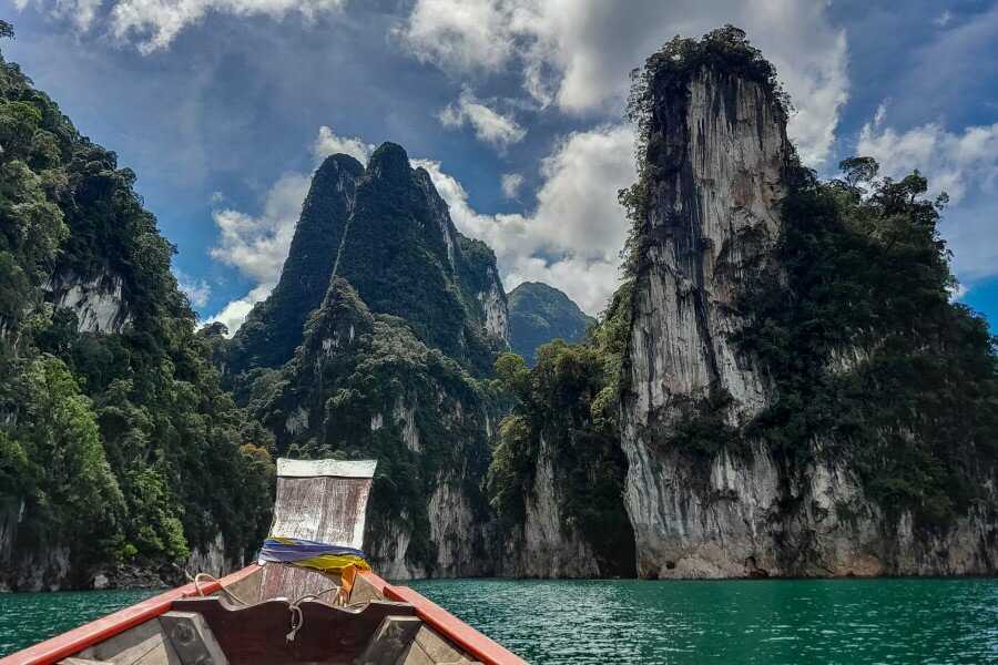 tall limestone cliffs covered with vegetation at cheow lan lake | Khao Sok floating bungalows