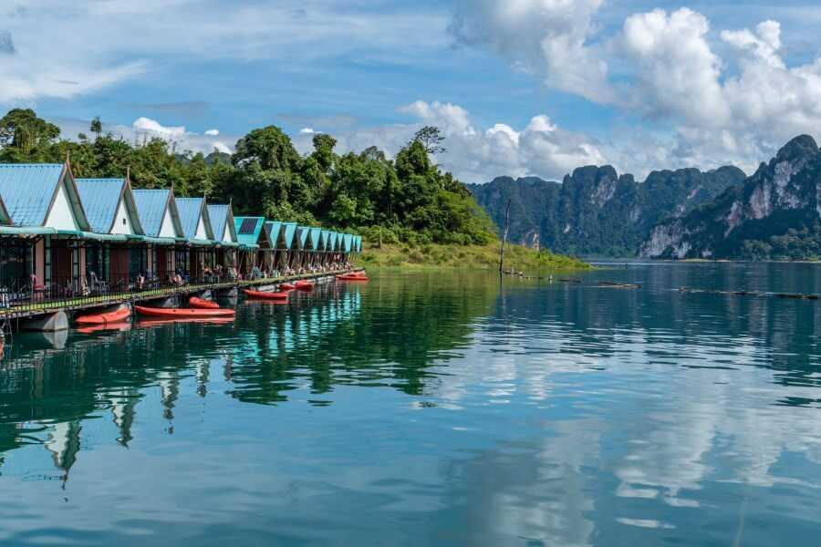rows of floating bungalows on Cheow Lan Lake surrounded by mountains and rainforest