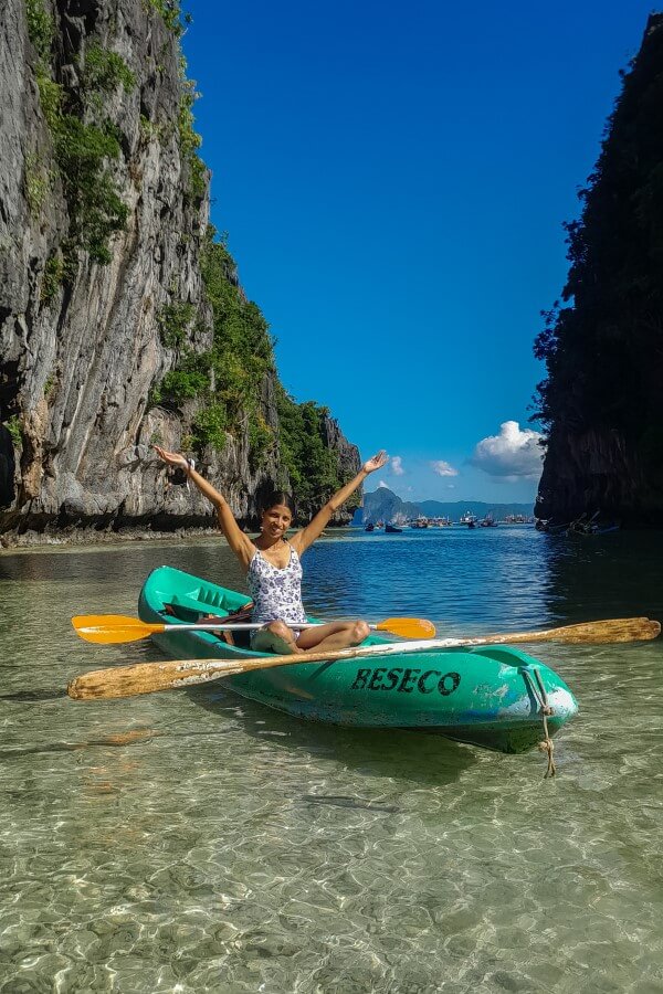 a woman in blue and white swimsuit on a kayak at big lagoon el nido philippines