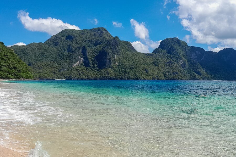 turquoise ocean with mountains in the backdrop at helicopter island el nido tour c