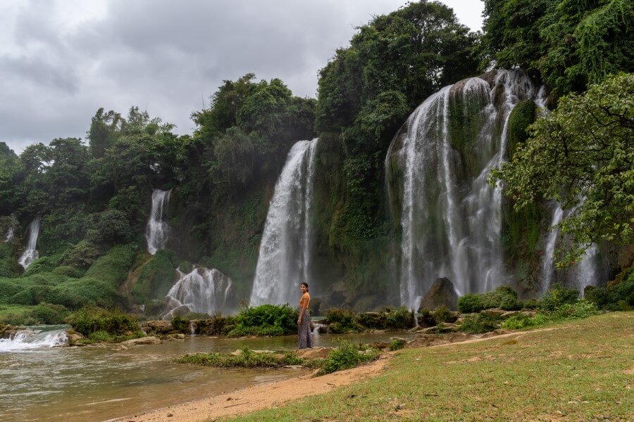 a woman posing in front of ban gioc waterfall in north vietnam
