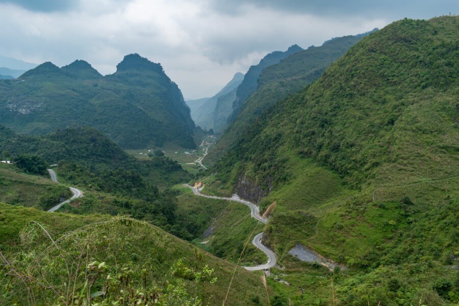 a viewpoint overlooking winding roads surrounded by mountains in ha giang northern vietnam