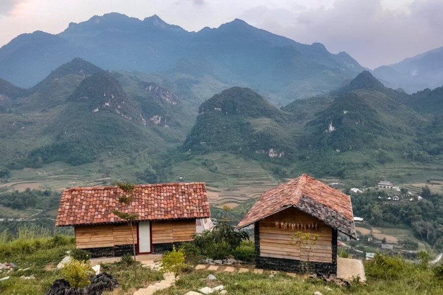 two small wooden houses on top of a mountain in ha giang