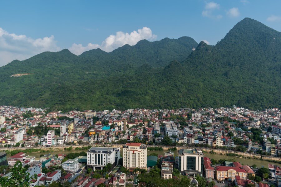 aerial view of buildings with mountains in the backdrop in ha giang | north vietnam itinerary
