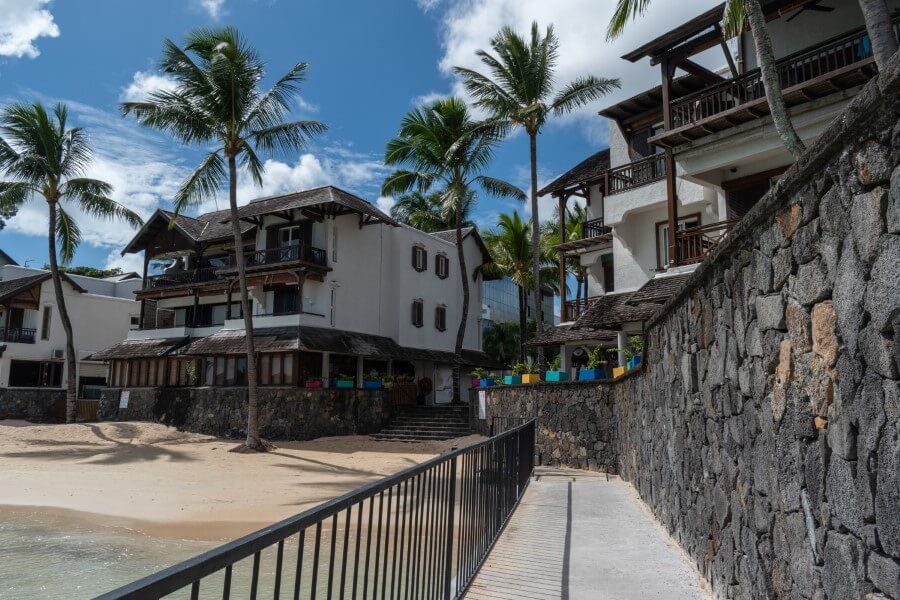 a concrete pathway leading to white-washed bungalows in grand baie mauritius