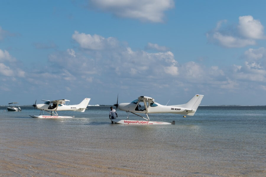 2 white seaplanes on a beach