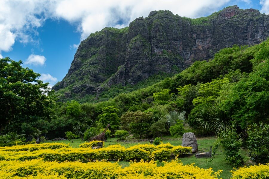 rock sculptures scattered in a garden at the foot of a mountain